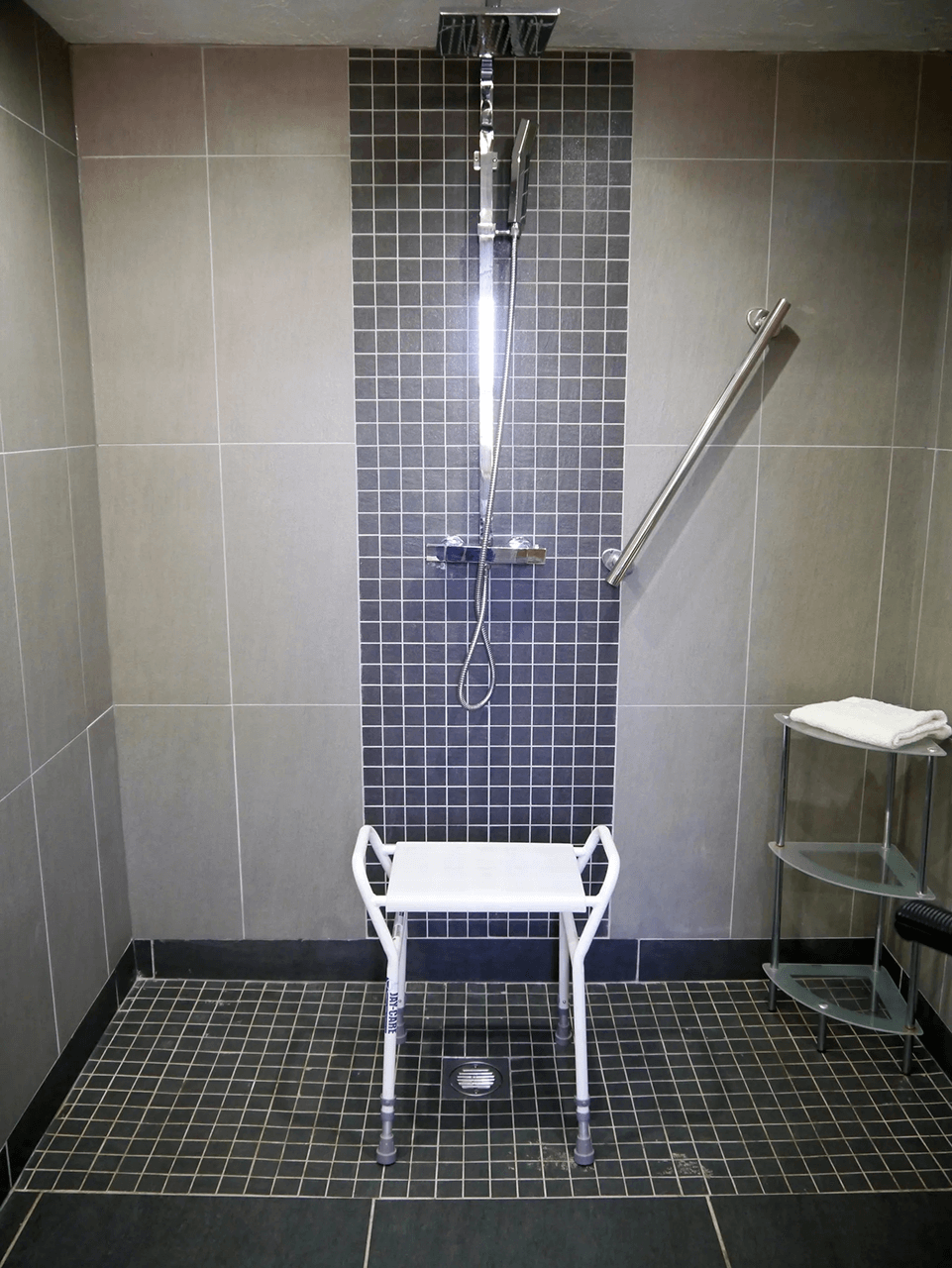 shower seat with side handles in shower room